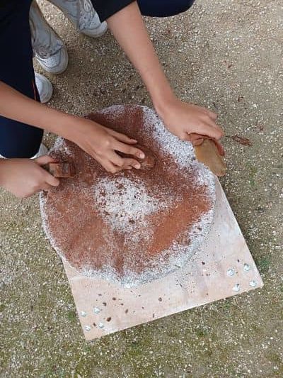 Polir le manche en écorce sur une meule en granit